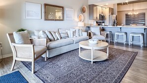 A modern living room with a sofa, chairs, a coffee table, and a patterned rug. - Heavenly Pointe | Penthouse Lake Views, Elevator, Accessible, King Beds (Branson)
