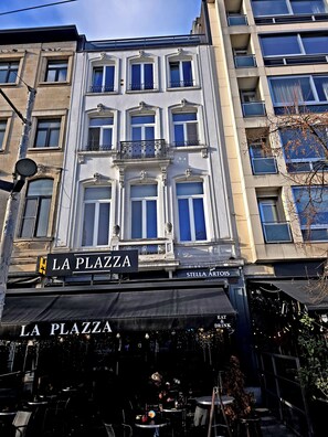 Um edifício com uma placa que diz "LA PLAZA" e "STELLA ARTOIS", indicando um restaurante.