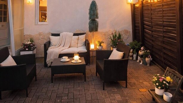 An outdoor patio with a sofa, chairs, a table, and potted plants. - Village house in a quiet location, green oasis vacation home (Hefersweiler)