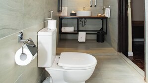A modern bathroom with a wooden ceiling, a toilet, a sink, and a mirror. - Spacious Junior Suite near UN Nairobi, Cozy Stead Garden House (Nairobi)