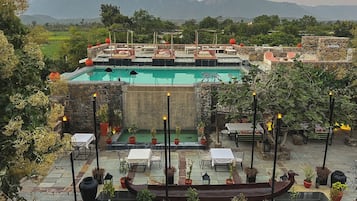 Una piscina al aire libre, sombrillas, sillones reclinables de piscina