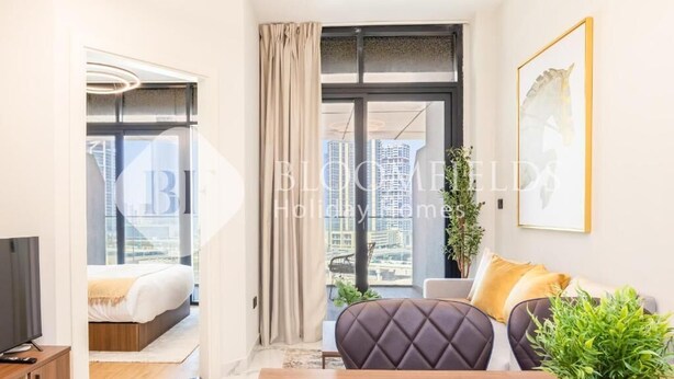A modern hotel room with a bed, a TV, a dining table, and a sofa. - Bloomfields 1Br Supremee Al Maryah  (Abu Dhabi)