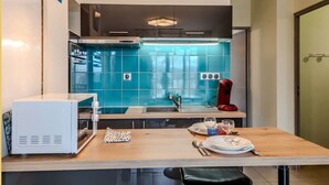 A modern kitchen with a central island, a microwave, and a red coffee maker. - Chez Dams I T2 I Annecy (Annecy)