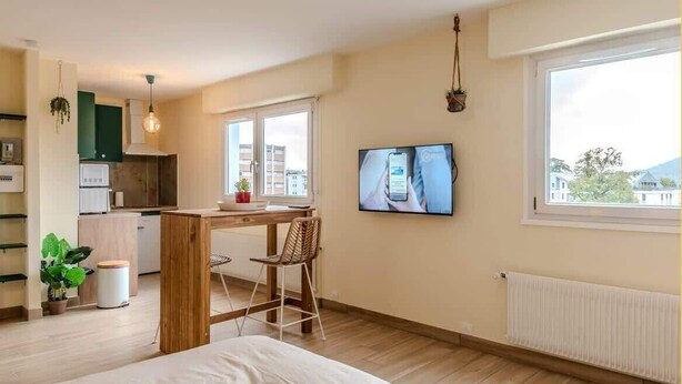 A modern bedroom with a bed, a desk, and a TV. - Chez Carole I Studio I Annemasse (Annemasse)