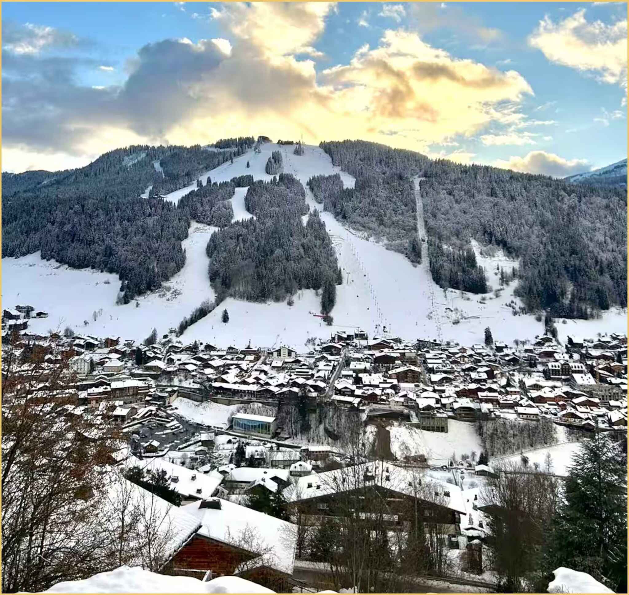 A snow-covered village with buildings and a mountain in the background.