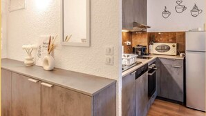 A modern kitchen with a wooden countertop, a microwave, and a sink. - Chez Noé I T2 I Thonon (Thonon-les-Bains)