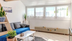 A modern living room with a blue sofa, a coffee table, and a radiator. - Chez Amel & Val I T2 I Annemasse (Annemasse)