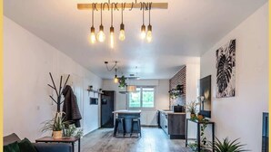 Un salon moderne avec un canapé, une table basse et une cuisine en arrière-plan.