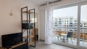 Ein modernes Wohnzimmer mit einem Flachbildfernseher, einem Holztisch und einem Essbereich mit Tisch und Stühlen.