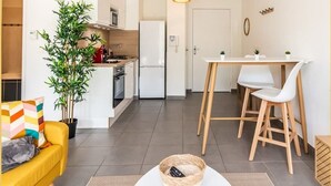 A compact living space with a kitchen, dining area, and a small seating area. - Chez Hubert | Proche Genève I Beaumont (Beaumont)