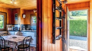 A wooden interior with a dining area, kitchen, and a door leading outside. - Le Chalet Brenor I Vue Lac I Lugrin (Lugrin)