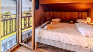 A wooden cabin room with a bed, a balcony, and a view of the outdoors. - Le Chalet Brenor I Vue Lac I Lugrin (Lugrin)