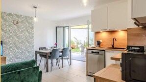Una cocina moderna con encimera de madera, lavavajillas integrado y microondas negro.
