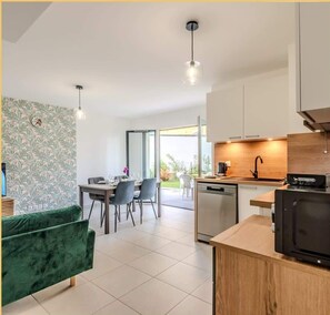 A modern kitchen with a wooden countertop, a built-in dishwasher, and a black microwave.