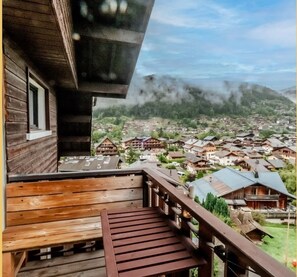 A wooden balcony with a view of a village and mountains in the background. - Chez Fran çois I T4 I Morzine (Morzine)