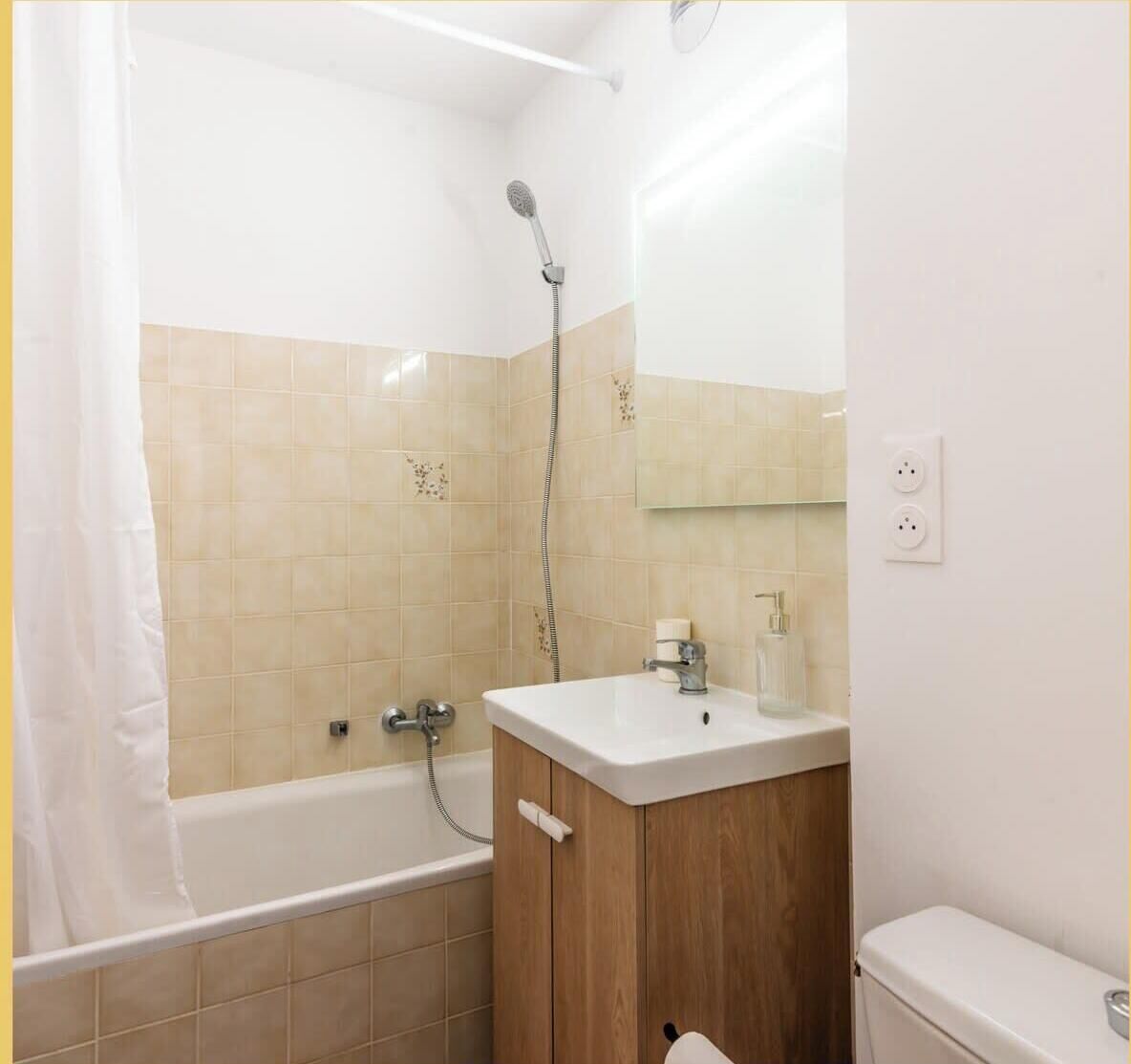A bathroom with a bathtub, a shower, and a sink with a mirror above it.