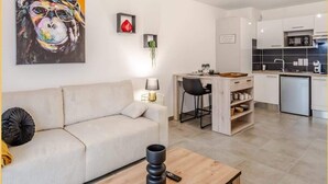 Una sala de estar moderna con un sofá, una mesa de centro y un cuadro en la pared.