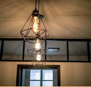 A geometric pendant light fixture with multiple bulbs, hanging from a ceiling. - Appart T3 | Elégant | Annemasse (Annemasse)