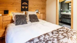 Ein Schlafzimmer mit Holzboden und Bett, Kissen und Decke.