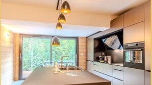 Una cucina moderna con isola centrale, elettrodomestici in acciaio inossidabile e luci a sospensione.