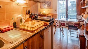 Una cocina moderna con armarios de madera, una estufa integrada y un amplio ventanal con vistas a un templo.