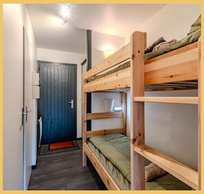 A bunk bed room with a door, a light fixture, and a small window. - Le Paradisio I Studio I Morzine (Morzine)
