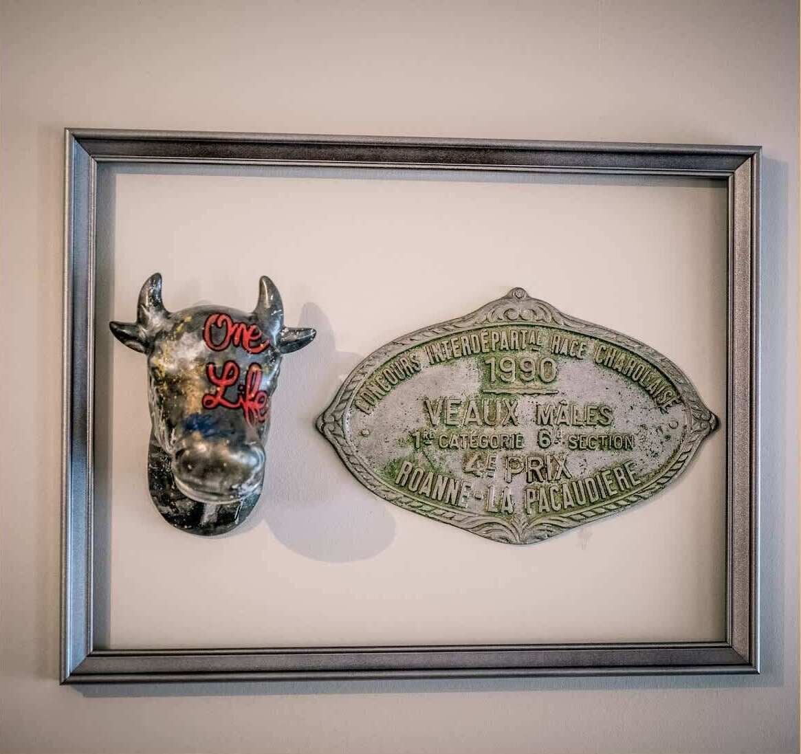 A framed plaque and a bull head sculpture.