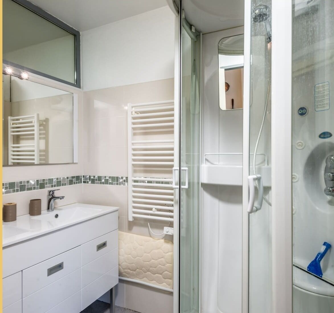 A modern bathroom with a glass-enclosed shower, a white sink, and a mirror above the vanity.