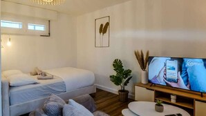 Ein modernes Schlafzimmer mit Bett, Nachttisch und Fernseher.