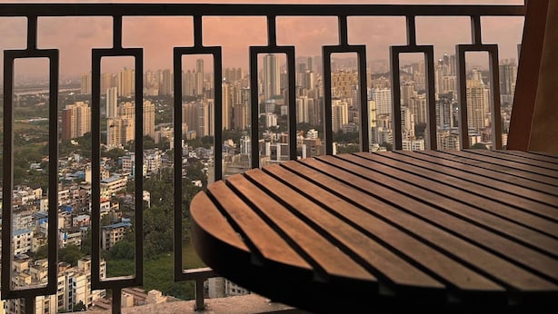A balcony with a view of a cityscape during sunset.