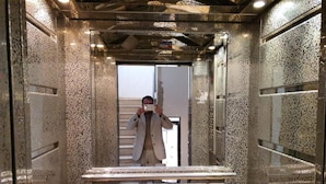 An elevator with a speckled granite finish and a mirrored wall. - Shahed Apartment 3-bedroom apartment in charming Amman with comfort (Amman)