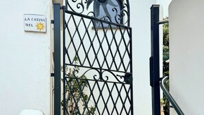 A gated entrance with a decorative metal gate and a sign reading "LA CASINA DEL".