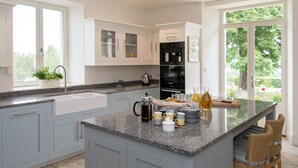 A modern kitchen with granite countertops, white cabinetry, and a large island.