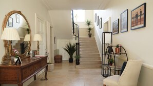 A staircase with a handrail, a wooden bench, and a chair.