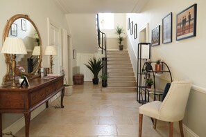Una escalera con barandilla, un banco de madera y una silla.