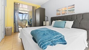A hotel room with a bed, a hammock, a view of the outdoors, and a painting on the wall. - Casa Elevación | Ocean-View Rooftop Retreat | Pool | Fiber WiFi (Playas Del Coco)