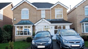 A two-story house with a garage, two cars parked in front, and a well-maintained lawn. - Room-private Double Room Ensuite in Ches (Waltham Cross)