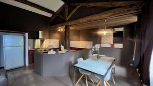 A kitchen with a central island, a dining table with chairs, and a refrigerator. - Soie - Fabulous 1-bedroom apartment in quaint Seillans (Seillans)