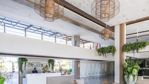 Eine moderne Lobby mit Empfangstresen, Sitzgelegenheiten und großen Fenstern.