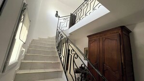 A staircase with a metal railing, a wooden cabinet, and a window with curtains. - Near Montpellier - Country house 8 to 10 persons (Saint-Clément-de-Rivière)