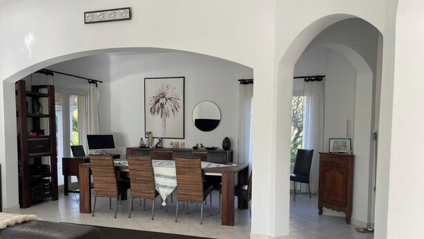 A modern living room with a dining area, featuring a sofa, a dining table with chairs, a TV, and a bookshelf. - Near Montpellier - Country house 8 to 10 persons (Saint-Clément-de-Rivière)