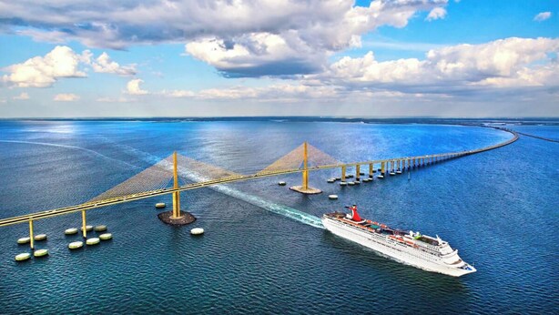 Un navire de croisière s’approche d’un pont qui enjambe une mer calme.