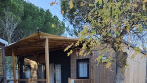 Eine Holzhütte mit Veranda, Tür und kleinem Fenster.