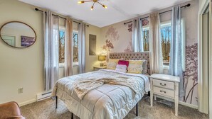 Un dormitorio con cama, mesita de noche y lámpara de techo.