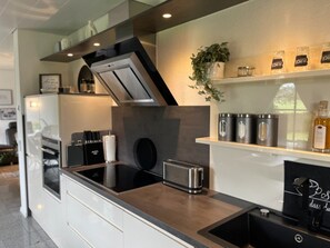 A modern kitchen with a built-in oven, a toaster, and stainless steel appliances.