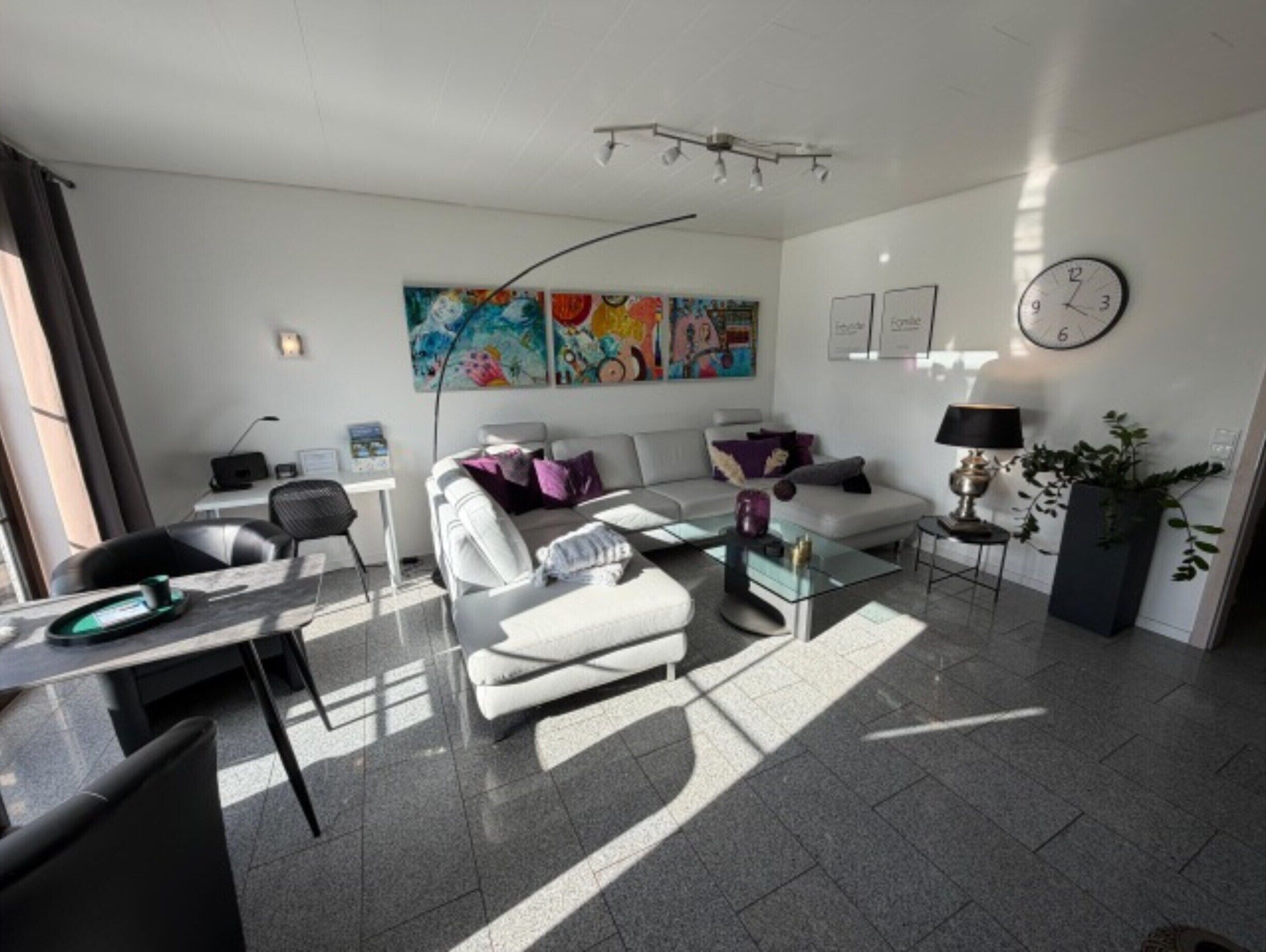 Ein modernes Wohnzimmer mit Sofa, Couchtisch und einem Kunstwerk an der Wand.