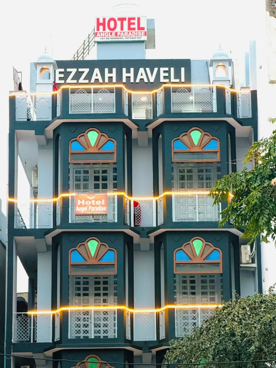 A multi-story building with a sign reading 'Hotel Angel Paradise' and 'Ezzah Havel'.