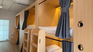 Bunk beds with curtains, wooden walls, and a number '5' visible. - Nana Best Hostel (Bangkok)