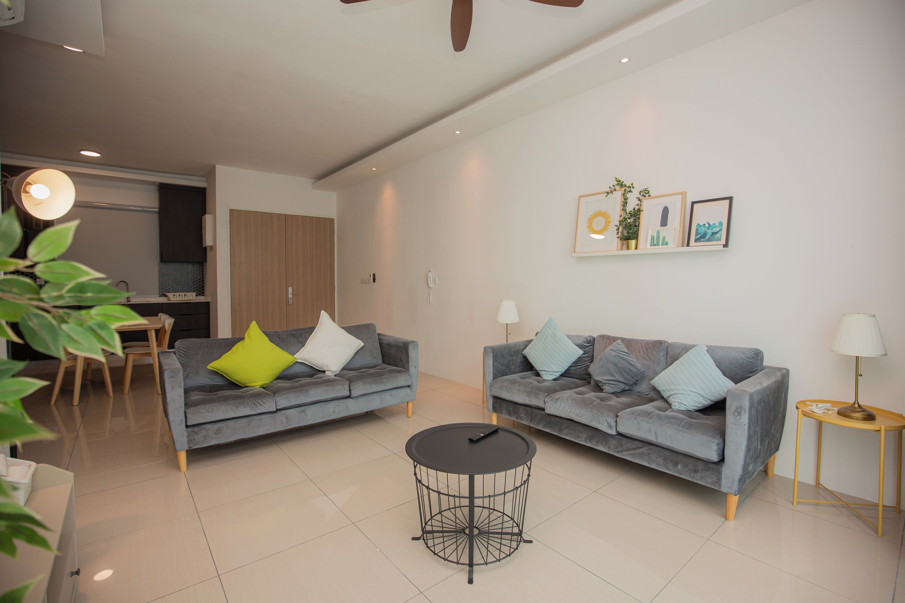 A modern living room with two grey sofas, a round coffee table, and a small side table.
