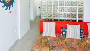Une pièce comprenant un lit, un miroir décoratif et un mur fait de blocs de verre.